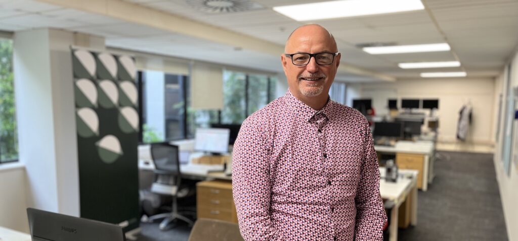 photo of Jamie Baddeley with office in the background