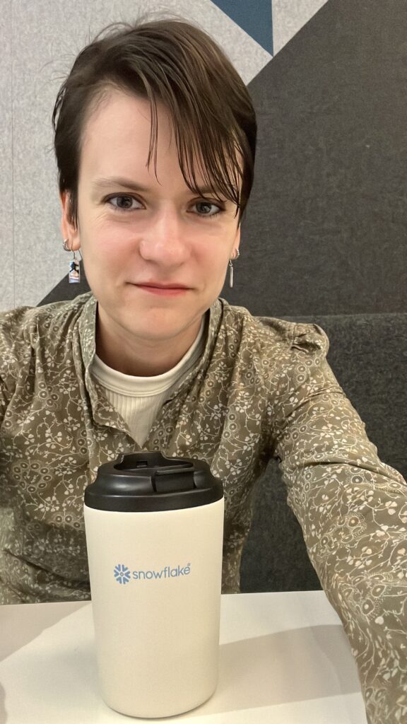 Selfie of Kate with a Snowflake logo on coffee cup.